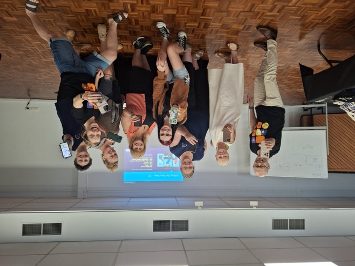 A community group holding up their phones at the end of a video training session
